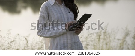 Young business woman having a job interview on the phone, doing business analysis, in the garden of the office, by the lake Royalty-Free Stock Photo #2381064829