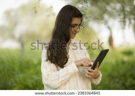 Young business woman having a job interview on the phone, doing business analysis, in the garden of the office, by the lake Royalty-Free Stock Photo #2381064845