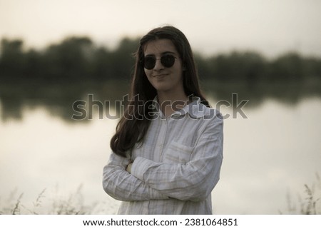 Young business woman having a job interview on the phone, doing business analysis, in the garden of the office, by the lake Royalty-Free Stock Photo #2381064851