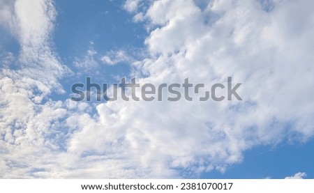 White, fluffy clouds spread out in the blue sky.  