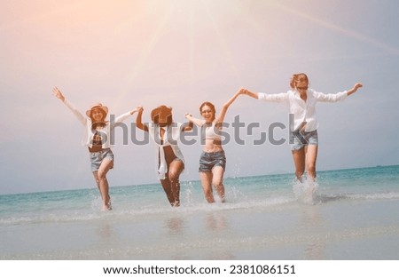 Four happy friends at sunset beach party runs to water, Silhouette group of teens holding hands and running together at the sunset sea, friendship and teamwork concept.