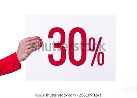 Female hand holding a 30% poster on white background. Studio shot.