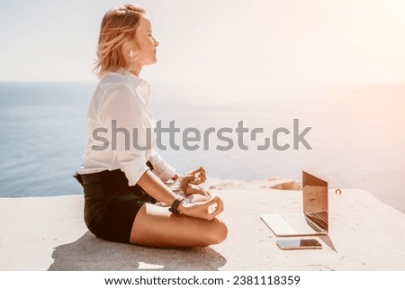 Woman sea laptop yoga. Business woman freelancer in yoga pose working over blue sea beach at laptop and meditates. Girl relieves stress from work. Freelance, digital nomad, travel and holidays concept