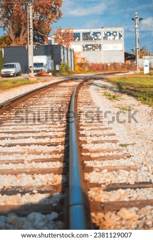 Picture of railway tracks with houses and power poles in the background 