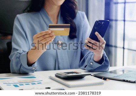 Woman using smart phone for mobile payments online shopping, omni channel, sitting on table, virtual icons graphics interface 