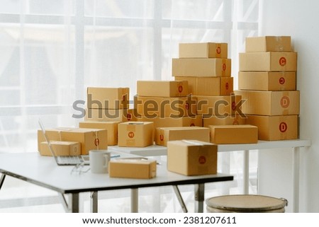 Small start-up business owners checking parcels at work, salespeople, checking production orders. Pack products for delivery to customers Sell ​​Ecommerce Shipping Ideas Royalty-Free Stock Photo #2381207611