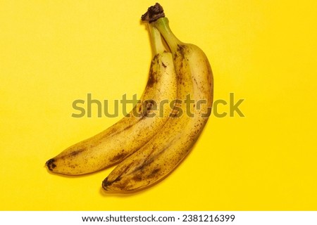 The macro picture on a yellow background shows two yellow bananas with black dots, it turns out that they are unripe.