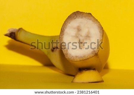 Bananas are on the way to extinction, the macro picture of a banana is pictured on a yellow background like the peel of this fruit.