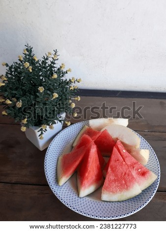 Fresh watermelon and pear on a patterned plate with floral decoration