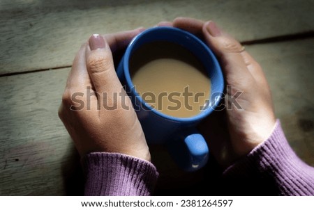 Sipping mochaccino, her delicate hand cradles the warm cup