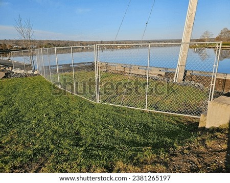 A large fence running along the side of a shore to prevent people from getting near the water.