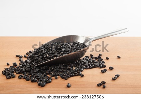 Black beans with transfer scoop on wood table