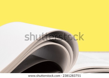 open book. Composition with hardback books, fanned pages on wooden deck table and yellow background. Books stacking. Back to school. Copy Space. Education background. Tuition payment.