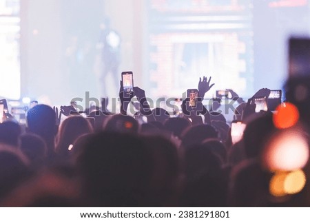 People taking pictures and recording at the big concert. Close-up shot. Streaming at the concert. High quality photo