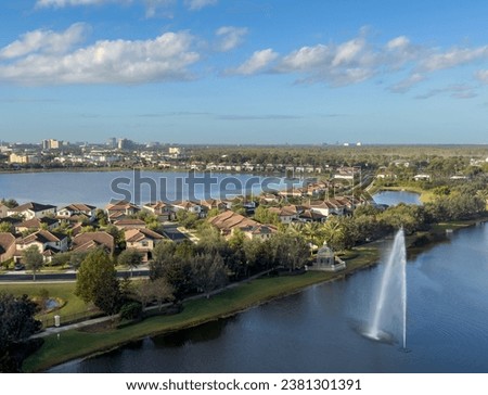 Aerial view of lake fountain, homes, and Disney Springs in background at Orlando, Florida.