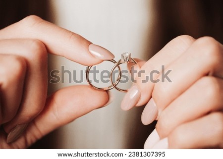 Wedding ring background. Engagement ring. Girl holding rings. Woman hands wedding and diamond engagement ring. Shallow depth of field. Love symbol. Golden jewelry. Marriage happy time. Royalty-Free Stock Photo #2381307395