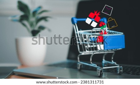 Shopping cart and gift box icons placed on laptop computer represent online shopping concept, website, market platform, technology, e-commerce, shipping, logistics and online payment concept.