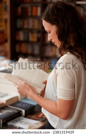Woman, bookstore and reading with shopping, research and thinking in profile, learning and ideas. Girl, novel or literature in store, library or choice for deal, discount or retail sale with search Royalty-Free Stock Photo #2381319439