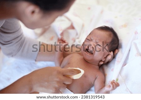Newborn, crying and cleft palate with cleaning, mom and bed with parent, sick and frustrated. Medical issue, syndrome and home bedroom for healthcare, childcare and mouth for baby, pain and sadness Royalty-Free Stock Photo #2381319543