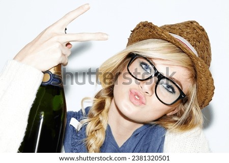 Woman, face and portrait with champagne or peace sign of nerd, geek or hipster against a studio background. Attractive female person with glasses, nerdy or fashion style holding bottle of alcohol