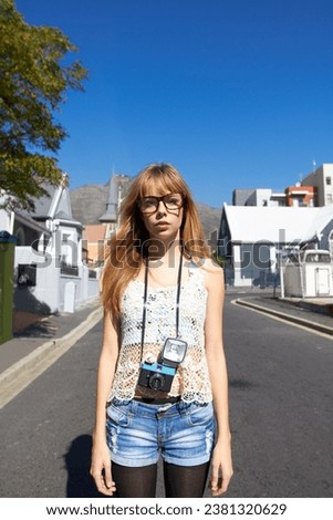 City, photographer and portrait of serious woman with camera for creative and art career traveling. Gen z, paparazzi and young female person from Australia with dslr equipment for vacation in town.