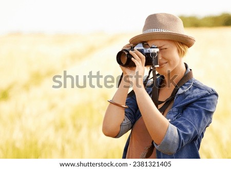 Woman, camera and photography with safari, vacation and holiday with wheat field and plants. Nature, photographer and outdoor with traveler blog and countryside with photo for adventure and journey