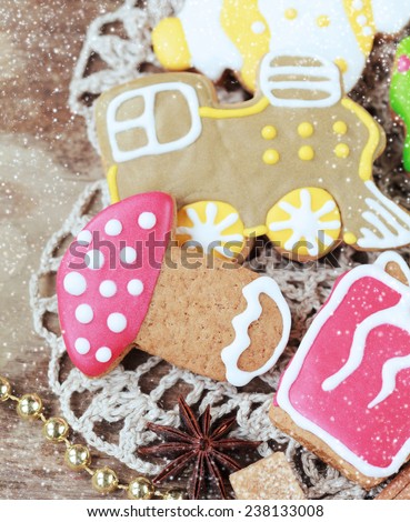 Homemade christmas painted gingerbreads on the wooden background with Christmas decorations. Selective focus and place for text. Toned and snow
