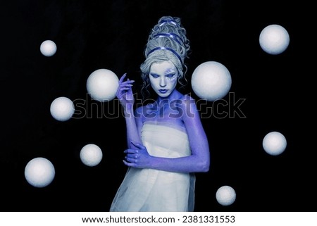 Attractive woman witch fairy standing with white planet spheres on black background. Astrology, magic, fantastic and space concept