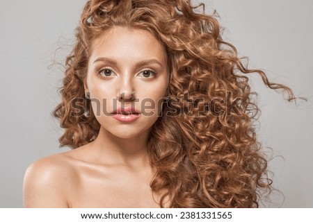 Perfect young redhead woman with long healthy wavy red hair. Natural beauty without retouching. Beautiful curly hair female model, closeup portrait Royalty-Free Stock Photo #2381331565