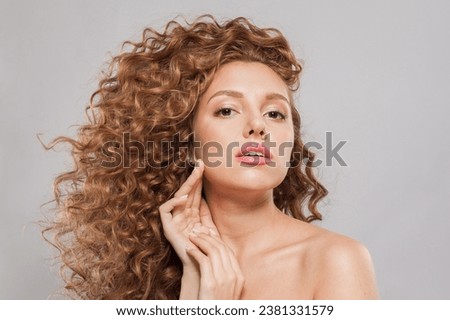 Young redhead woman with long healthy wavy red hairstyle. Natural beauty without retouching. Beautiful curly hair model