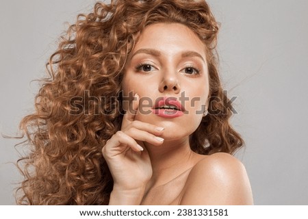 Pretty young redhead woman with long healthy wavy red hair posing on white background. Natural beauty without retouching. Beautiful curly hair redhead lady