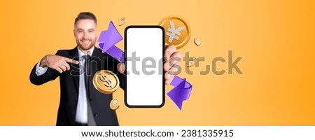Businessman finger point and showing smartphone blank display, gold dollar and yen or yuan coins with purple arrow. Concept of online banking, money exchange and conversion