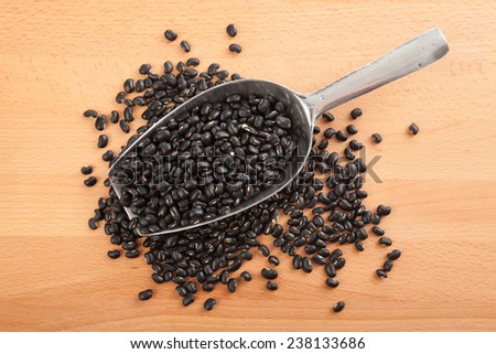 Black beans with transfer scoop on wood table