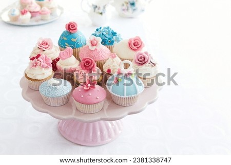 Assortment of beautiful cupcakes on a cakestand for afternoon tea Royalty-Free Stock Photo #2381338747