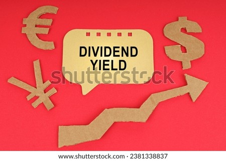 Business concept. On the red surface there are money symbols, an arrow and a sign with the inscription - DIVIDEND YIELD