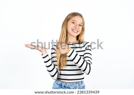 caucasian kid girl wearing striped T-shirt Showing palm hand and doing ok gesture with thumbs up, smiling happy and cheerful.