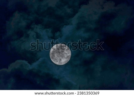 A big full moon between clouds                               