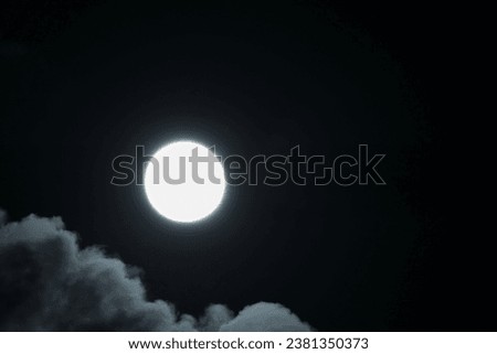 A big full moon between clouds                               