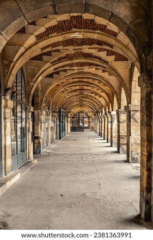The arcade in the Place des Vosges in Paris Royalty-Free Stock Photo #2381363991