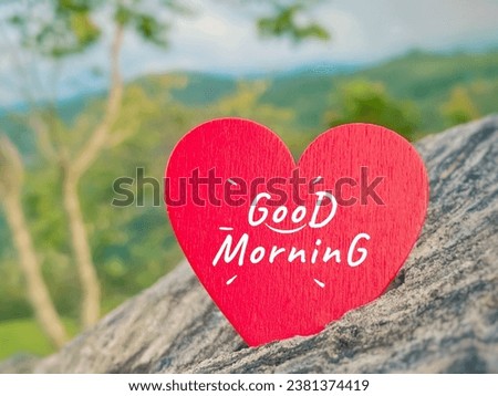Inspirational Quote Concept - good morning text on red heart shape with blurred nature background.