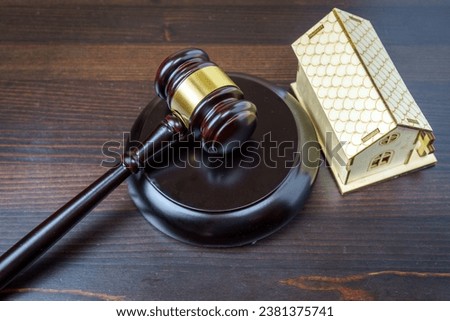 Concept of real estate auction, legal system and division of property after divorce. Gavel and house key on a wooden background. Royalty-Free Stock Photo #2381375741