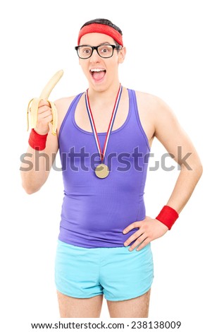 Young male athlete eating a banana isolated on white background