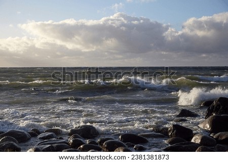 Windy day on the seashore with waves on the sea and cloudy sky above, selective focus. High quality photo