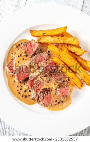 Steak au poivre - french steak with peppercorn sauce with french fries Royalty-Free Stock Photo #2381382537