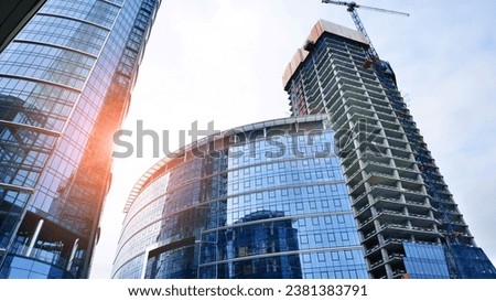View of a skyscraper under construction. Modern architecture background. Building a high-rise building,  the concept of real estate construction. 