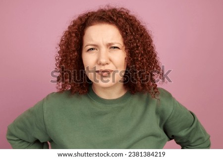 Studio portrait of puzzled suspicious female standing over pink background with hands on waist, squinting eyes trying to figure out complicated situation, uncertain with making right decision Royalty-Free Stock Photo #2381384219
