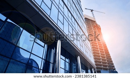 View of a skyscraper under construction. Modern architecture background. Building a high-rise building,  the concept of real estate construction. 