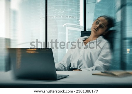 Sleepy young european businesswoman silhouette sitting at desk with laptop on abstract blurry city background. Success, workplace, ceo and future concept. Double exposure