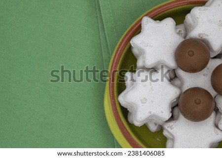 christmas cookies in the shape of a star and balls in a bowl