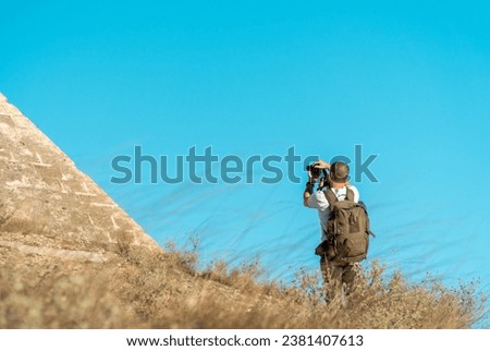 Young man as a photographer taking pictures outdoors.